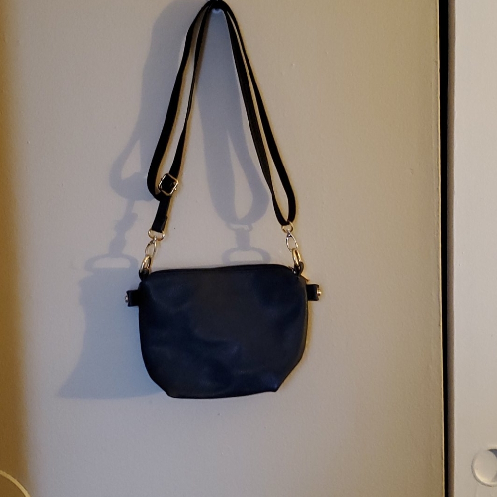Black purse with  shoulder strap that adjusts